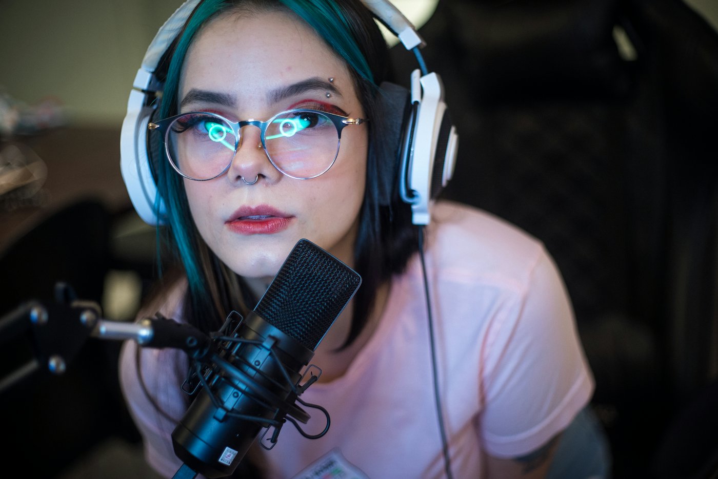 A creator with headphones speaking into a studio microphone
